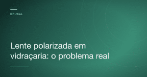 Close de uma lente polarizada sobre uma superfície de vidro mostrando um padrão de faixas coloridas em formato de arco-íris